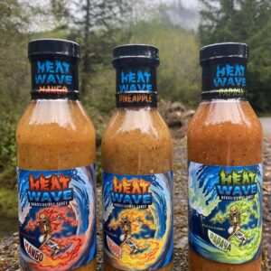 Three 12 oz bottles of Heatwave Hotsauce — Mango, Pineapple, and Papaya — displayed as a tropical flavor pack delivering sweet and spicy Caribbean hot sauces.